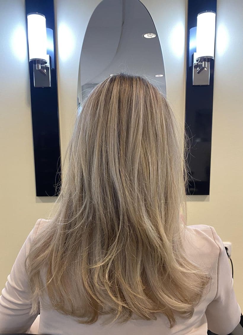 Haarverdichtung, nachher: Feines blondes Haar, das nach unten hin dünn ausläuft. Danach durchgehende Fülle bis in die Spitzen, gleiche Länge, gleicher Farbton.