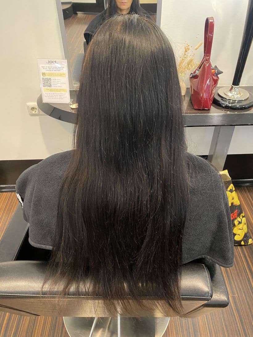 Haarverlängerung und Haarverdichtung, vorher: Dunkles Haar, vorher flach anliegend und dünn auslaufend. Danach deutlich mehr Länge und Volumen, in Wellen gestylt.